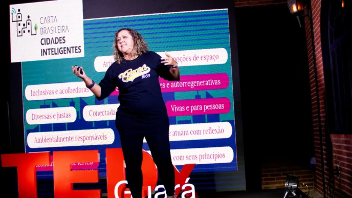 As contribuições de Cristiane junto à Carta Brasileira de Cidades Inteligentes A palestrante em uma entrevista recente para uma emissora de TV, explica como entrou no campo das cidades inteligentes contribuindo para o desenvolvimento da Carta Brasileira de Cidades Inteligentes, e posteriormente começou a trabalhar em projetos através do Instituto Multiplicidades. Um desses projetos, Hackacity Guará, visa implementar uma cidade inteligente em um bairro ou região específica, fornecendo oportunidades para a juventude local desenvolver ideias e negócios inovadores, e, finalmente, viver e trabalhar na cidade onde moram. O projeto, que é apoiado pelo Ministério da Ciência, Tecnologia e pela administração de Guará, com foco em educação, tecnologia e inserção no mercado para os jovens participantes tem sido uma referência em termos de políticas públicas aplicadas ao desenvolvimento de uma maneira de colaborar com os moradores da cidade. Entre algumas ações de sucesso no tema do empreendedorismo de inovação e promoção da economia digital e criativa, um Hackathon realizado na Faculdade Projeção, direcionou as ideias para os problemas reais da cidade e as três ideias empreendedoras de sucesso que ganharam a gincana receberam financiamento por meio de uma bolsa FAPDF, totalizando R$ 60.000 para saírem do papel. Uma dessas ideias foi a implementação de um posto de saúde em Guará, que visava gerenciar e distribuir medicamentos para a população local por meio de um aplicativo de celular. Outra ideia foi o desenvolvimento de um aplicativo para controlar e monitorar medicamentos dentro do posto de saúde. A palestrante também mencionou projetos em andamento, incluindo “Igualando Oportunidades”, que se concentra em inserir jovens negros no mercado de trabalho.